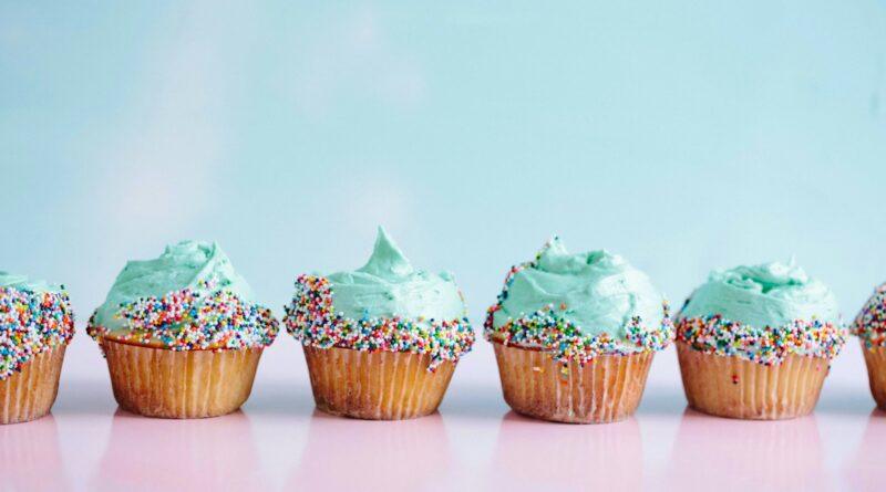 six teal icing cupcakes with sprinkles